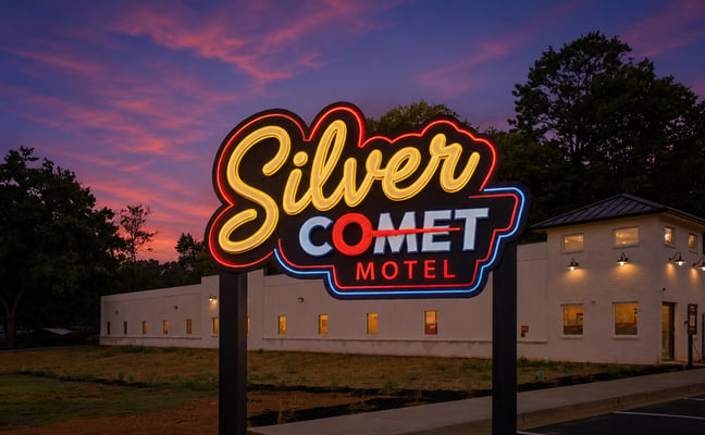 Silver Comet Motel neon sign glowing at sunset with the motel building lit up behind it